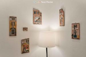 une lampe sur un mur avec des photos de bâtiments dans l'établissement L'Antica Piazzetta, Terre Marine, à Monterosso al Mare