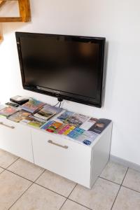 a flat screen tv sitting on top of a white cabinet at Da Massimo - Casa Vacanze in Levico Terme