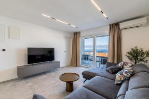 a living room with a couch and a tv at Bracera Luxury Apartments in Slatine