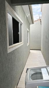 a view of a room with a window and a tub at Casa aconchegante in Rio das Ostras