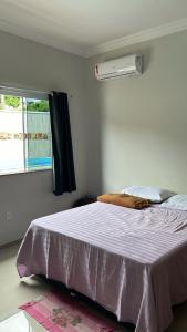 a bedroom with a large bed with a window at Casa aconchegante in Rio das Ostras