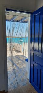 an open door with a view of the beach at Harmonia Beach House in Kimolos