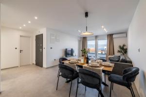 a dining room and living room with a table and chairs at Bracera Luxury Apartments in Slatine