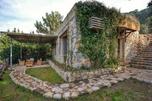 a stone house with ivy on the side of it at Blue Jay Valley in Jezzîne