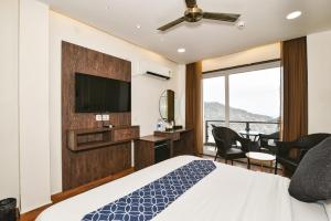 una camera d'albergo con un letto e una TV a schermo piatto di AH Grand Villa a McLeod Ganj