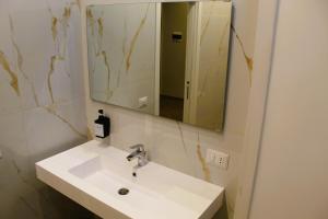 a bathroom with a white sink and a mirror at BlackWoody Contemporary Rooms - Napoli Centro Storico Via Toledo in Naples