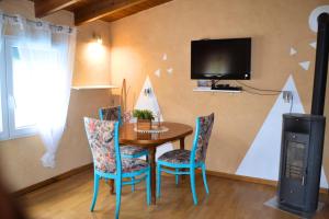 ein Esszimmer mit Tisch und Stühlen und einem Fernseher in der Unterkunft Naturgelegenes Resort in Alboy