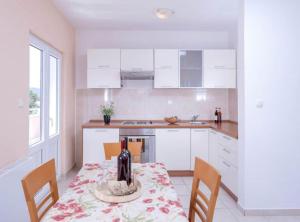 una cocina con una mesa con una botella de vino. en Ena Apartments, en Vrboska