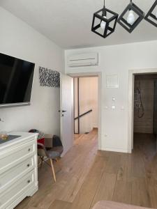 a living room with a white dresser and a tv at SOBE DELUX Vodice in Vodice