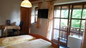 a bedroom with two beds and a large window at Pension Aufeld in Landsberg am Lech