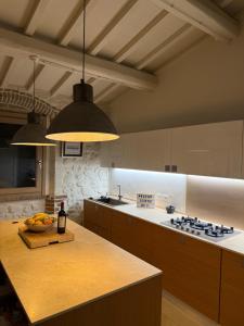 a kitchen with a island with a counter top at Casa Leoni Chianni - tuscan luxurious Villa in Chianni