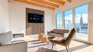 a living room with a couch and a tv at ANDRISS - Stilvolle Lofts & Penthouses - Premium Wohnen mit Parkplatz & Workstations in Kaiserslautern