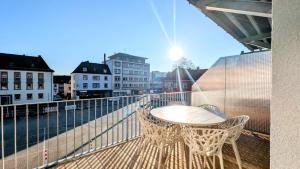 a table and chairs on a balcony with a view at ANDRISS - Stilvolle Lofts & Penthouses - Premium Wohnen mit Parkplatz & Workstations in Kaiserslautern