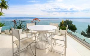 a white table and chairs on a balcony overlooking the water at Gallery Luxury Suites & Rooms-Only Adults in Split