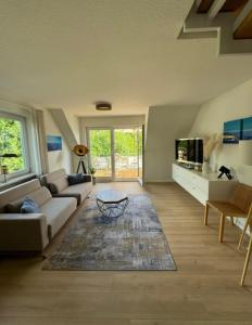 a living room with a couch and a table at SEEgold in Unteruhldingen