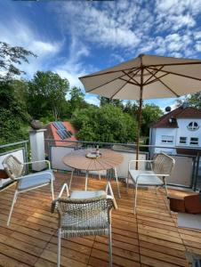 a patio with a table and chairs and an umbrella at SEEgold in Unteruhldingen
