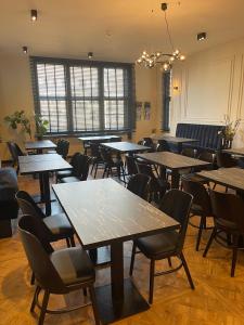 a dining room with tables and chairs and a chandelier at Motel Blue Messe in Berlin