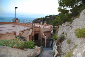 a house on a hill next to the ocean at Villa Arborea in Sperlonga in Sperlonga