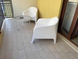 two white chairs and a table on a balcony at Stanza Platone in Corigliano Calabro +1 photo