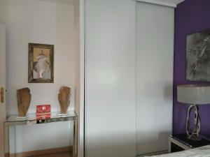 a bedroom with a sliding door and a table with a lamp at Location chambre 2 personnes chez Angela in Cannes