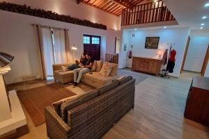 Dos personas sentadas en un sofá en una sala de estar en The North House by Ponta Negra Azores, en Biscoitos