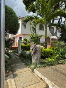 カリにあるApartamentos Sur de Cali Amplios bien ubicadosの家の前に腰掛けた切り株
