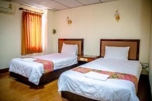 攀牙Lukmuang 2 Hotel的有两张床和一扇窗户的酒店房间