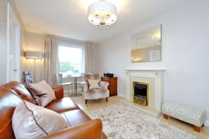 a living room with a couch and a fireplace at Fonthill Apartment - central, free parking off street in Aberdeen
