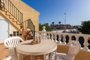 a table and chairs on a balcony with a staircase at Bungalow en Gran Alacant con Terraza y piscina comunitaria in Puerto Marino