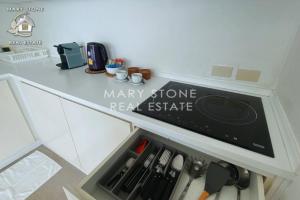 a kitchen with a counter top with a stove at V2 Sunset Seaview BangPor in Ban Bang Po