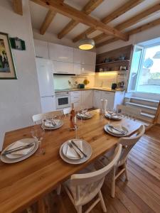 a wooden dining room table with chairs and a kitchen at Waterfront House Carolina in Vis +23 photos