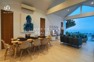 a dining room with a table and chairs and a couch at Villa Azula - Stunning Seaview in Ban Bang Po