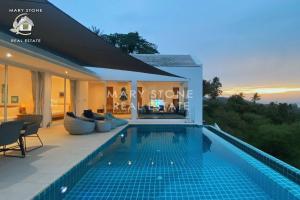 a villa with a swimming pool at sunset at Villa Azula - Stunning Seaview in Ban Bang Po