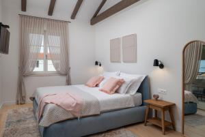 a bedroom with a bed with pink pillows at Luxury Villa Marca heated pool 36m2 in Nin +69 photos