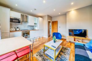 a living room with a table and a kitchen at Stylish 1BR Prime Location Near Station and Shops in South Norwood