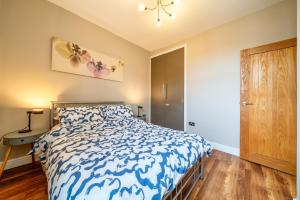a bedroom with a bed with a blue and white comforter at Stylish 1BR Prime Location Near Station and Shops in South Norwood +4 photos
