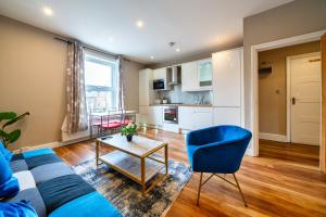 a living room with a couch and a blue chair at Stylish 1BR Prime Location Near Station and Shops in South Norwood