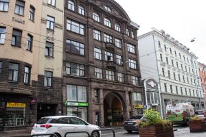 a white car parked in front of a building at Amber Apartment in Riga