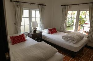 a bedroom with two beds and a window at 10mins to BKK airport 3BR Group Stay in Bangkok