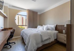 a bedroom with a bed with a desk and a mirror at Nohotel Premium Americana in Americana +32 photos