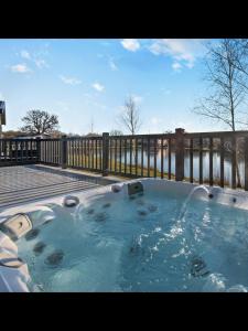 einen Whirlpool mit einem Brunnen im Hof in der Unterkunft Kingfisher Lodge - Lakeside Lodge With Hot Tub in Woodhall Spa