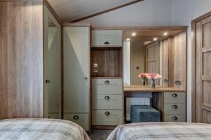 ein Schlafzimmer mit zwei Betten und einem Schreibtisch und einem Spiegel in der Unterkunft Kingfisher Lodge - Lakeside Lodge With Hot Tub in Woodhall Spa + 63 Fotos