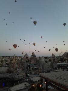 un grupo de globos de aire caliente volando sobre una ciudad en Mia Cappadocia Cave Hotel, en Göreme
