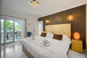 ein Schlafzimmer mit einem großen Bett, auf dem Handtücher liegen in der Unterkunft VillaCINCO in Sitio de Calahonda + 43 Fotos