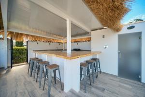 eine Außenküche mit Bar und Hockern in der Unterkunft VillaCINCO in Sitio de Calahonda