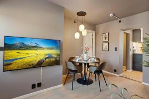 a dining room with a table and a large painting on the wall at Penthouse l Close To City Center l Balcony With City View l 3 bedroom in Drammen