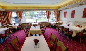 une salle à manger avec des tables et des chaises ainsi qu'une fenêtre dans l'établissement Hotel Sailer, à Sankt Anton am Arlberg