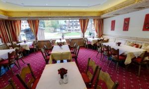 a dining room with tables and chairs and a window at Hotel Sailer in Sankt Anton am Arlberg