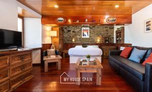 a living room with a couch and a bed at MyHouseSpain - Acogedor apartamento con terraza in Cudillero