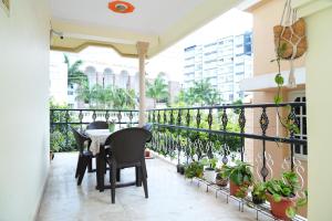 a balcony with a table and chairs and plants at Nele in Mysore